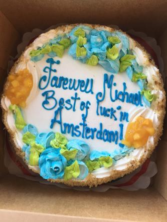 Cake that says "Farewell Michael. Best of luck in Amsterdam!"